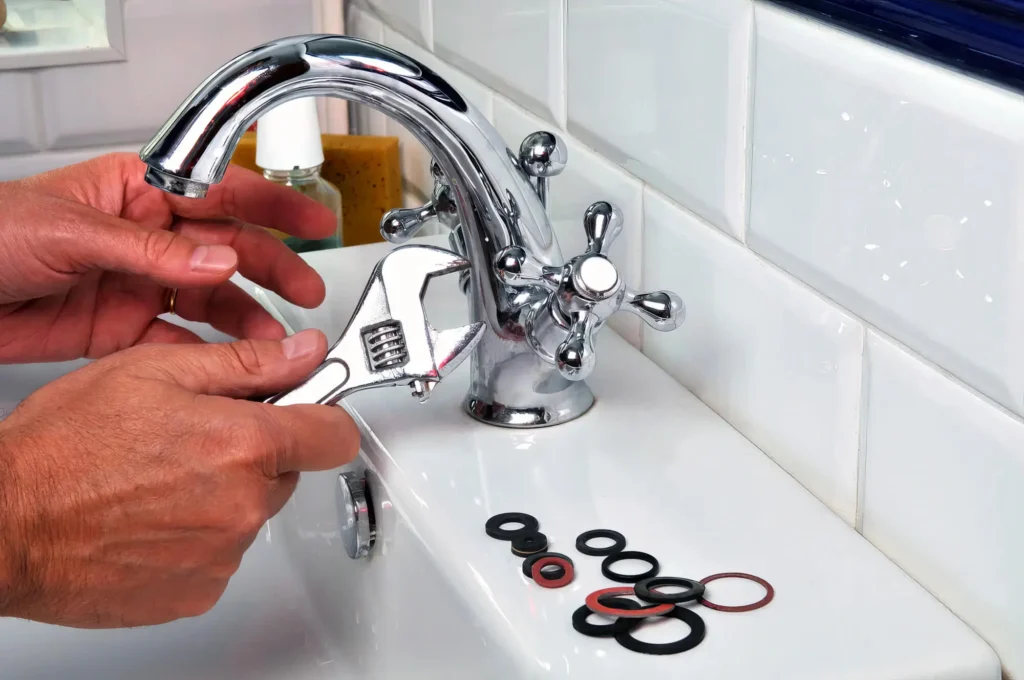 Plumber performing maintenance on a bathroom faucet in Leesburg