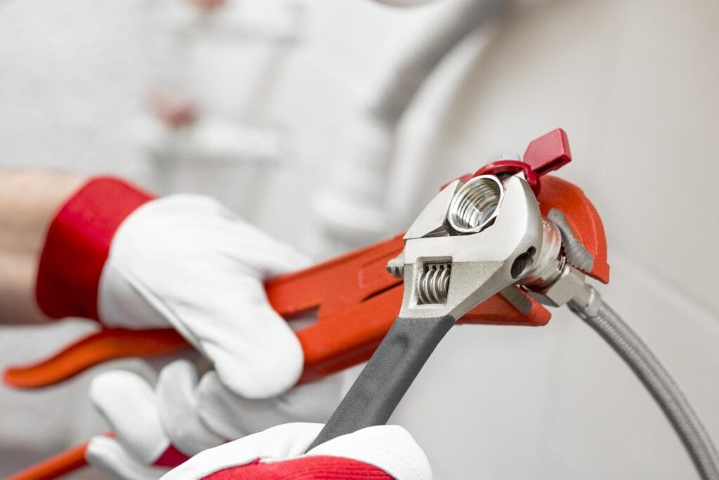 Plumber holding pipe wrenches for an emergency repair in Leesburg