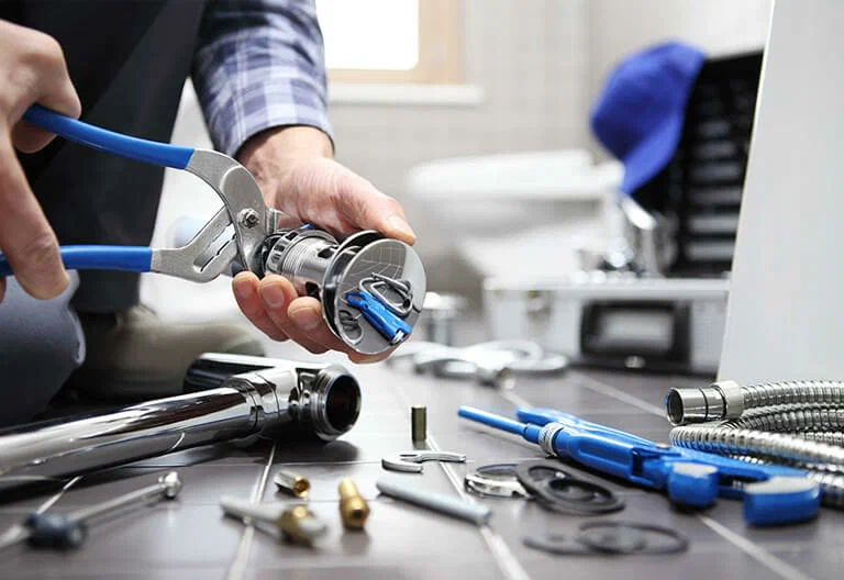 Technician repairing a plumbing fixture with professional tools in Leesburg