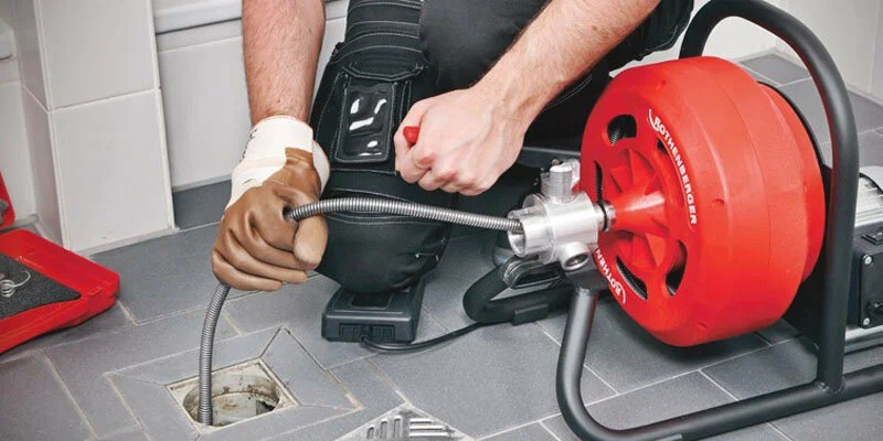 Plumber using a drain-cleaning machine in Leesburg