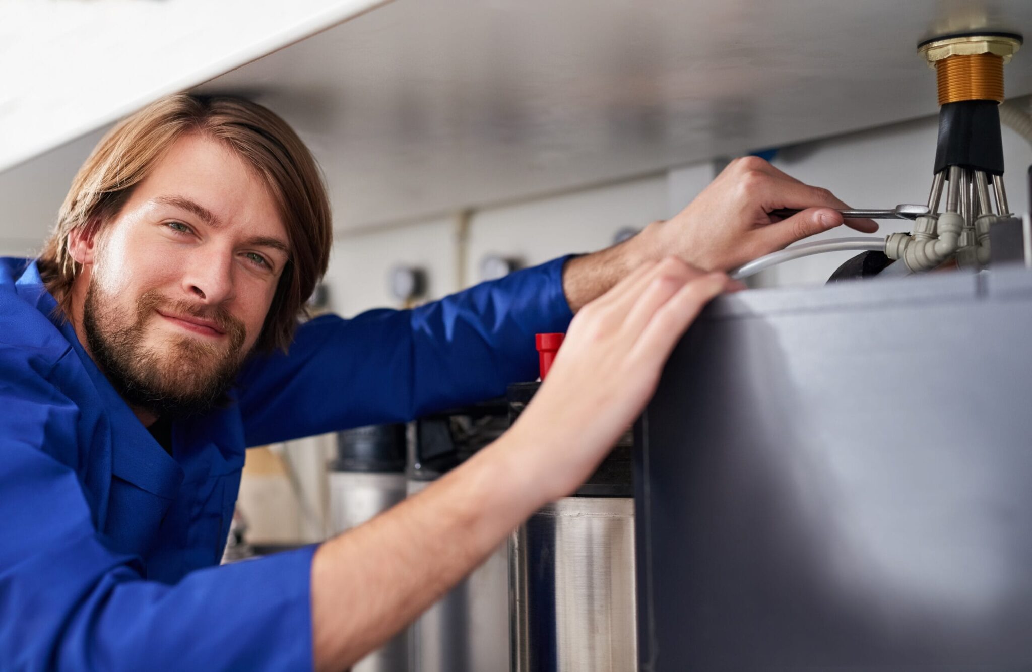 Technician servicing a residential water heater tank in Leesburg